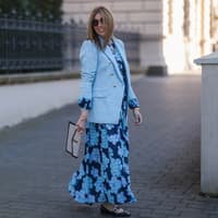 Wir verraten dir, welche Kleider für Hochzeitsgäste ab 50 Jahren besonders schmeichelhaft sind. Frau in hellblauem Kleid mit Blazer