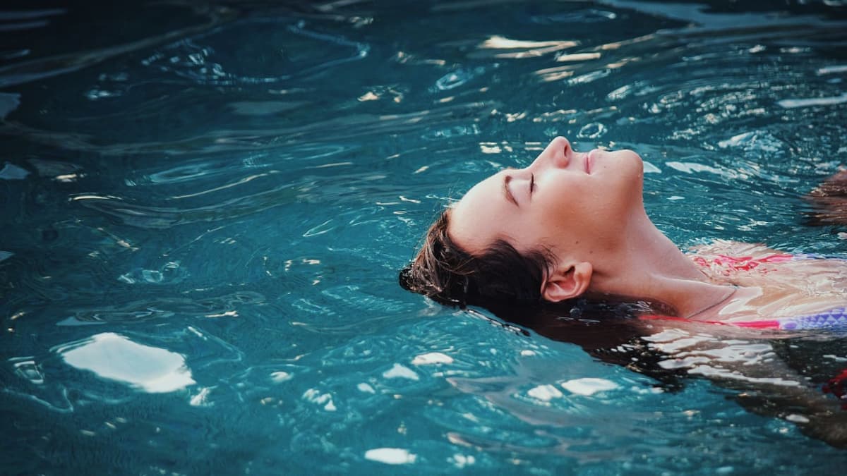 Eine Frau lässt sich im Pool treiben