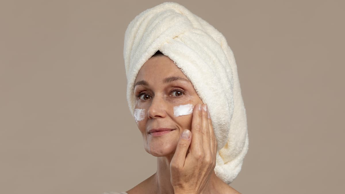 Frau cremt Gesicht ein