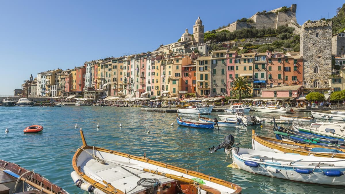 Ein Blick auf bunte Häuser und den Hafen von Portovenere mit kleinen Fischerbooten.