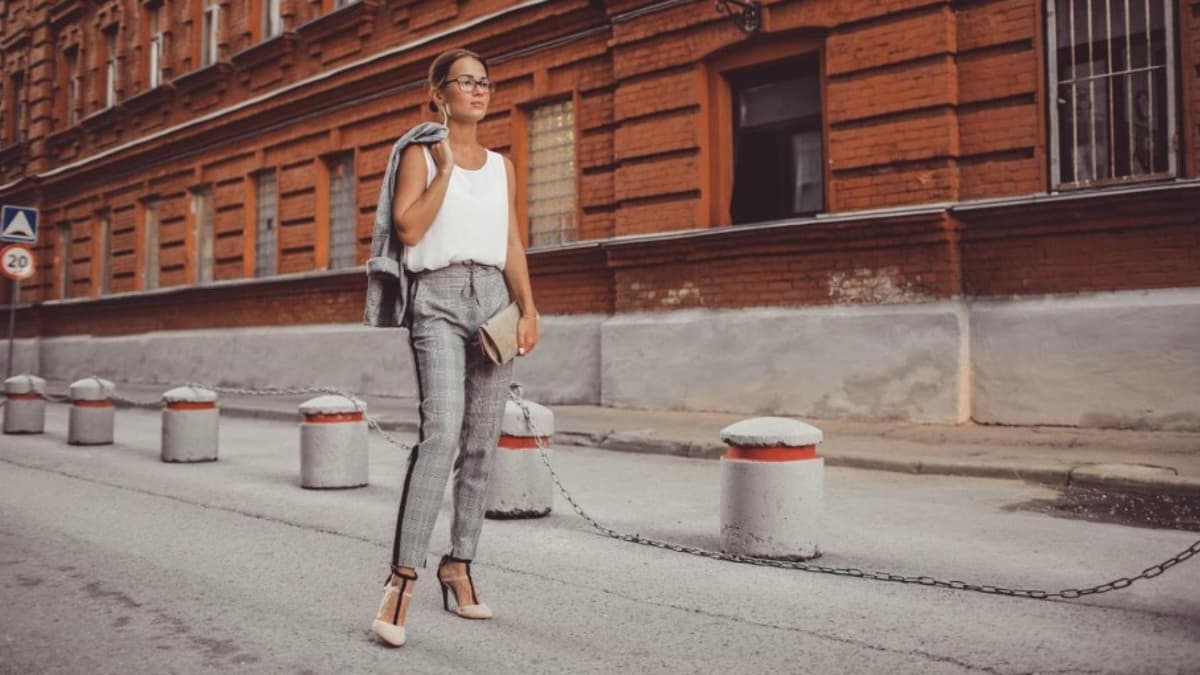 Frau läuft in stylischem Outfit auf der Straße