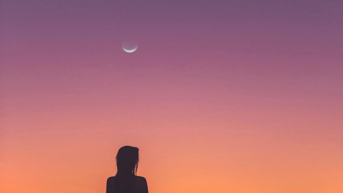 Frau schaut in den Abendhimmel