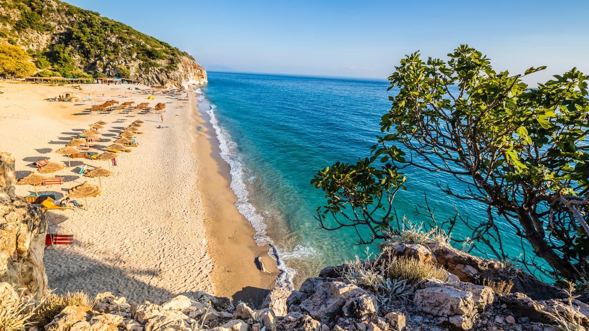 Ein Strand in Himare in Albanien mit türkisblauem Wasser und rauer Natur.