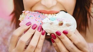 Frau mit lackierten Fingernägeln isst Kuchen