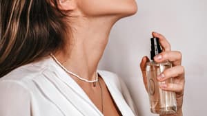 Frau trägt Parfum auf