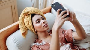 Frau mit Handy auf Sofa