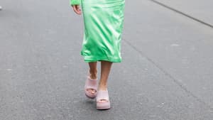 Frau mit grünem Rock und Pullover und rosa Sandalen