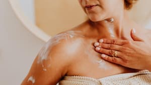 Frau trägt Bodylotion auf