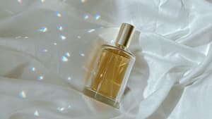 Parfum Flakon liegt auf einem Bettlaken mit Licht und Schatten