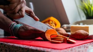 Frau schneidet Süßkartoffeln