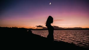 Frau mit Mond am Strand