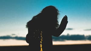 Silhouette einer Frau vor einem blauen Himmel