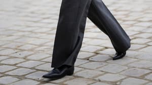 Stylische Frau trägt auf Paris Fashion Week Ankle Boot und graue weite Hose plus Jacke