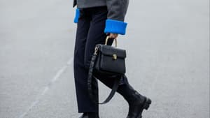 Aline Kaplan trägt schwarze Aigner Tasche schwarze Boots und graue Wolljacke