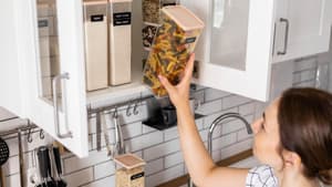 Frau sortiert ihren Küchenschrank