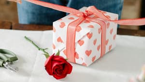 Frau packt ein Geschenk mit Herzen ein