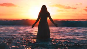 Frau im Kleid steht vor dem Sonnenaufgang im Meer 