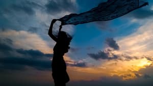 Frau mit Tuch in der Hand im Sonnenuntergang