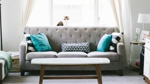 Grauer Sofa mit türkisen Kissen