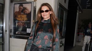 Katie Holmes mit Sonnenbrille, Bluse und Karottenhose. 