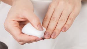 Nagellack von den Fingernägeln mit einem Wattepad entfernen