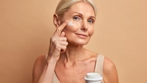 Frau trägt Creme aufs Gesicht