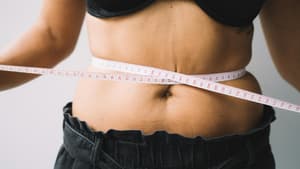 Maßband um den Bauch einer Frau