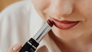Frau schminkt sich mit Lippenstift.