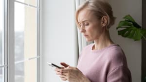 Frau guckt skeptisch auf ihr Handy.