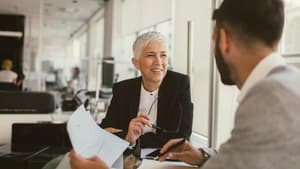 Frau sitzt mit einem Mann im Büro am Schreibtisch