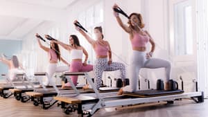 Vier Frauen machen Reformer Pilates.