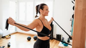 Frau strecht ihren Körper mit einem elastischen Band.
