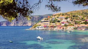 Die Küste von Kefalonia mit bunten Häusern und Booten auf dem Wasser.