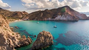 Das Meer an der Küste der Insel Milos mit zwei Segelbooten drauf.