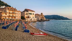 Strand von Cilento mit Häusern, Liegen und Sonnenschirmen.