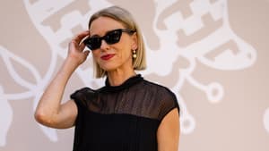 Frau mit kurzen, blonden Haaren, roten Lippen und einer schwarzen Sonnenbrille.