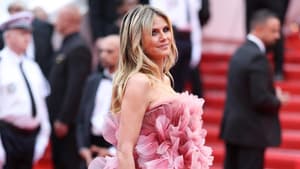 Heidi Klum auf dem roten Teppich in einem floralen Kleid in Rosa mit Blütenblättern.