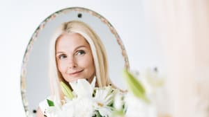 Blonde Frau schaut in den Spiegel