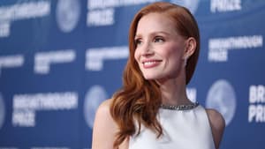 Jessica Chastain mit langen roten Haaren, silbernen Ohrringen und einem weißen Kleid schaut zur Seite.