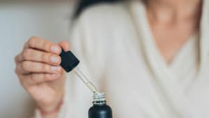 Frau öffnet Hautpflege-Serum