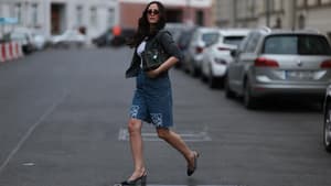 Frau mit dunklen Haaren und Sonnenbrille trägt Jeans-Shorts mit Slingback-Pumps.