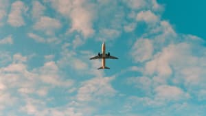Flugzeug unter blauem Himmel mit Wolken
