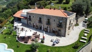 Die Villa Ginevra in Italien mit Blick von oben auf das Haus, die Terrasse und den Garten.
