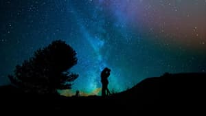 Ein Paar steht unter einem Sternenhimmel