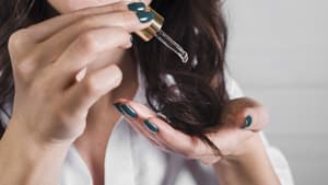 Frau trägt Haaröl auf