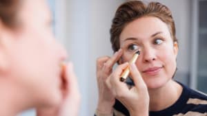 Frau trägt Concealer auf