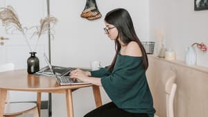 Eine junge Frau sitzt am Laptop