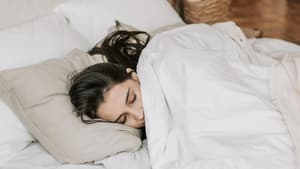 Eine Frau schläft in ihrem Bett