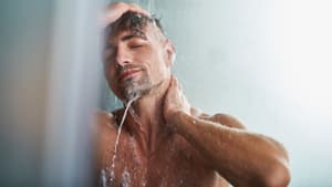 Ein Mann steht unter der Dusche
