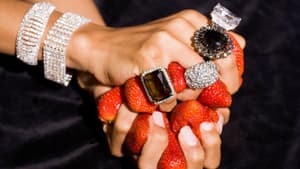 Frau mit großen Ringen hält Erdbeeren